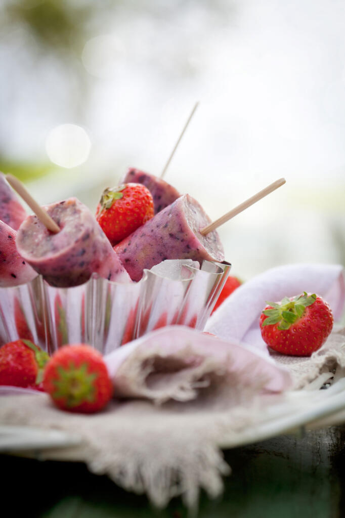 Fresh honey berry popsicles inspired by popbar with fresh berries on table with napkin