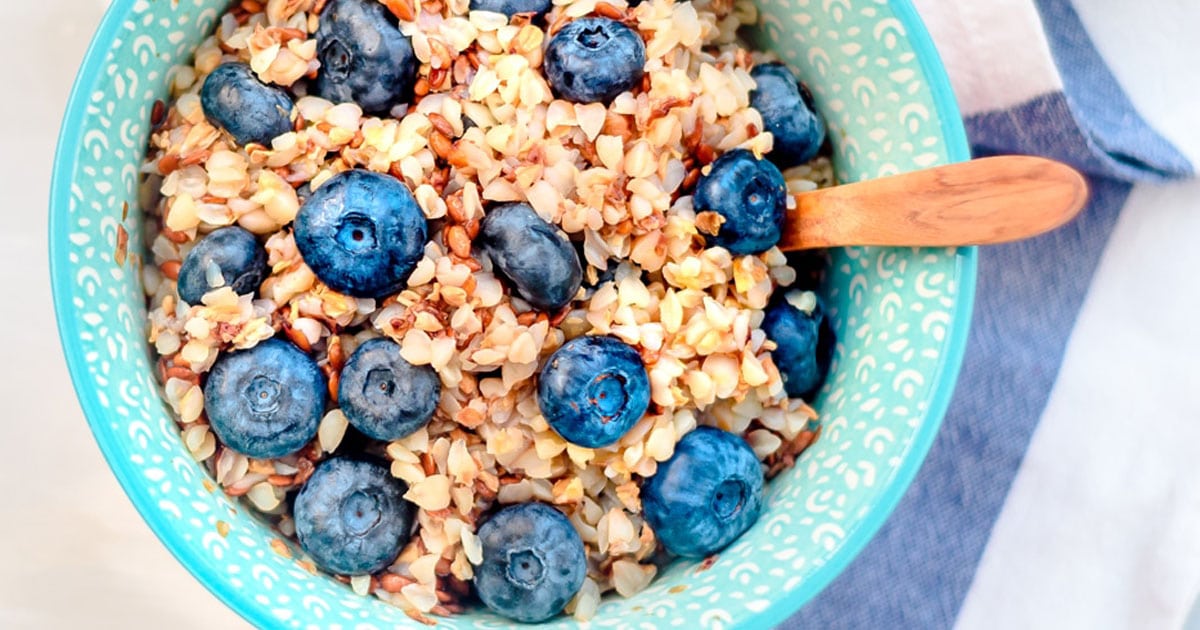 buckwheat breakfast bowl closeup with blueberries and blue striped napkin