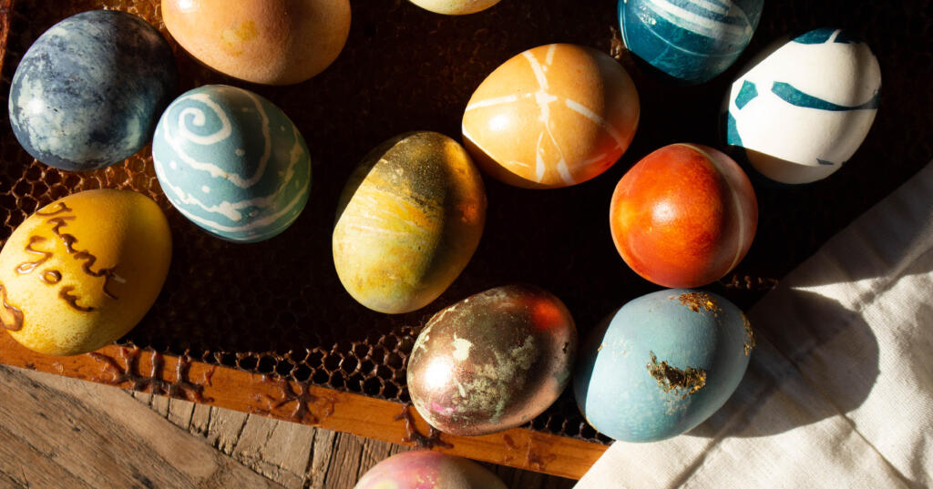 Naturally dyed easter eggs in shades of yellow, blue, teal, and orange