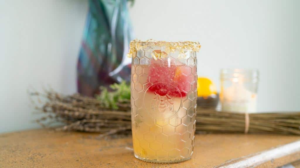 Lemon Vodka Cocktail with honey lollipop rim on counter