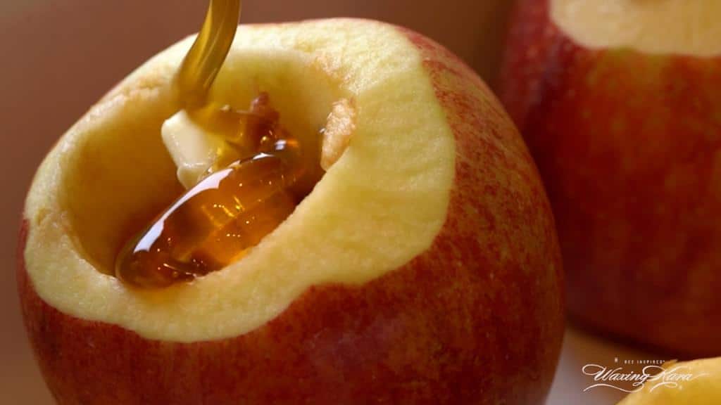 Honey baked apples being filled with honey