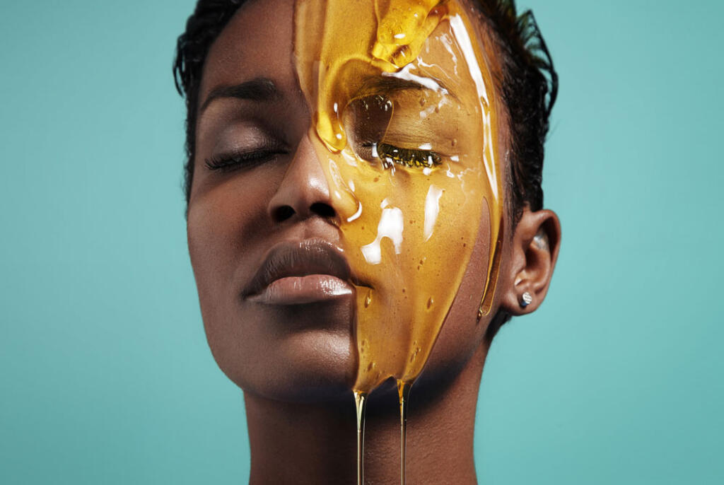 Honey Skincare Model with eyes closed and a jar of honey on her face