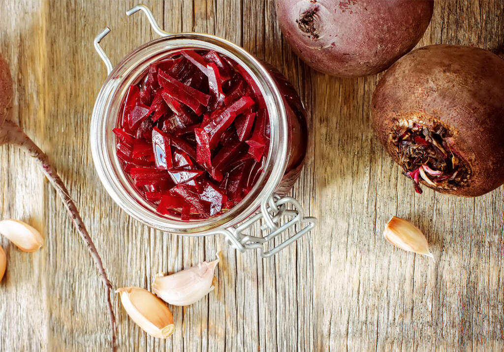 honey pickled beets in a mason jar with garlic cloves on wood table