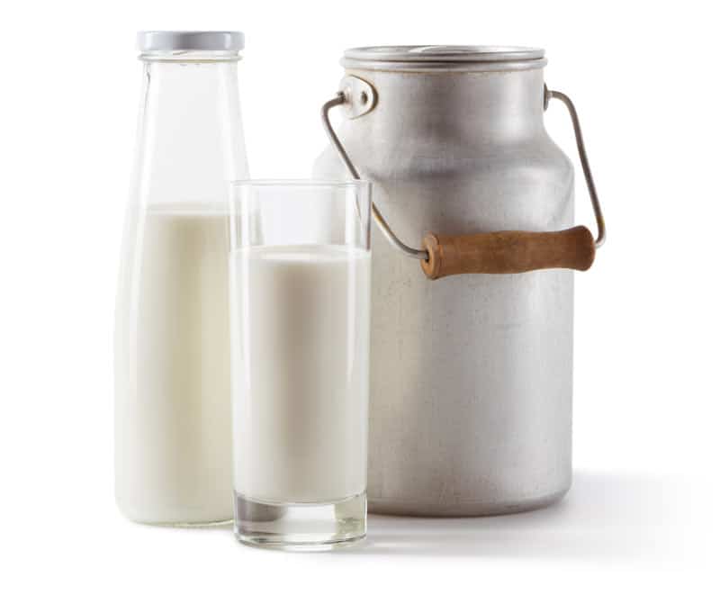 Picture of milk in a glass and bottle next to a metal milk can