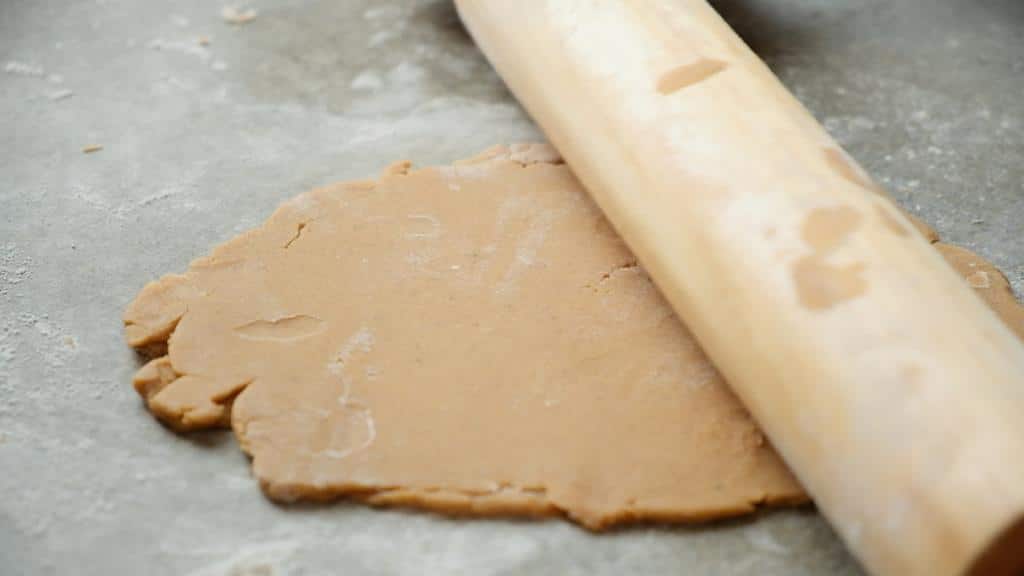 rolling pin and gingerbread cookie dough on countertop