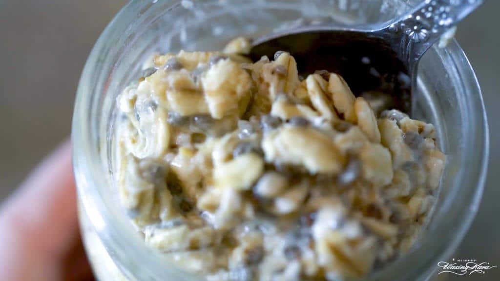 close up of overnight oats in glass jar with spoon