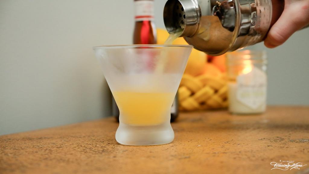 Screwdriver cocktail being poured into chilled glass on kitchen counter