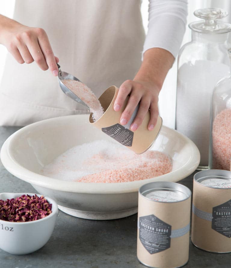 Making Mineral Bath Salts in white bowl with packaging nearby