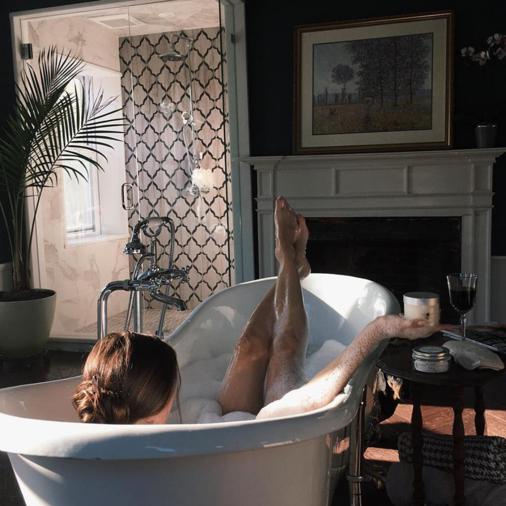 Bee Inspired Spa Scrub on table besides woman in bathtub