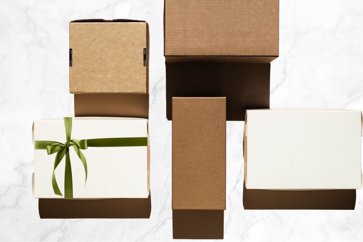 Packages on a marble table top, one package has an olive green ribbon