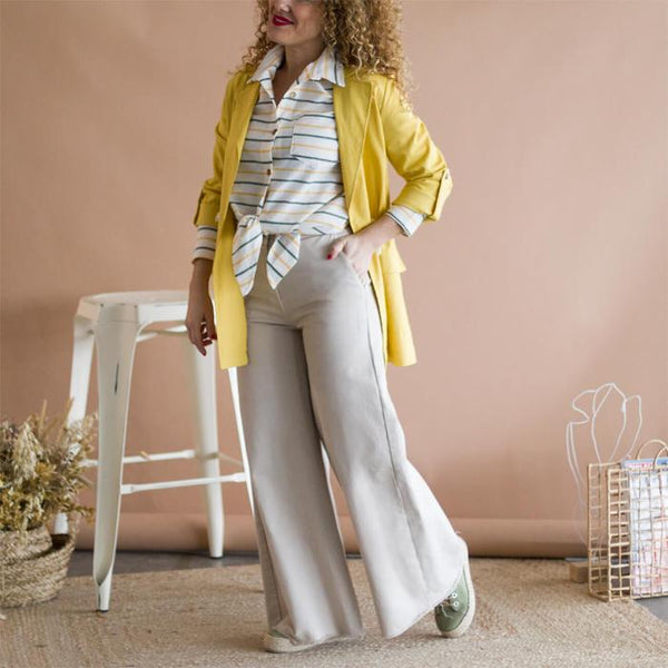 Look pantaloni a zampa con camicia a righe e giacca gialla