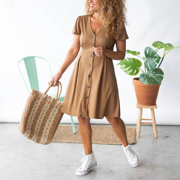 Look brown dress with sneakers and raffia bag