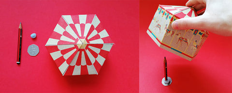 make shift card spinning stand from a pencil, coin and bluetac on a red backdrop