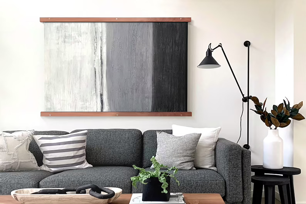 Living room with a black, white ad grey art piece in a magnetic hanger frame.
