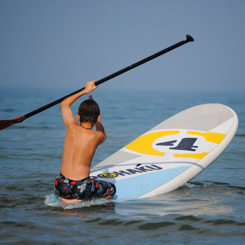 Child sits while paddling an All ROunder shaped Stand Up Paddleboard