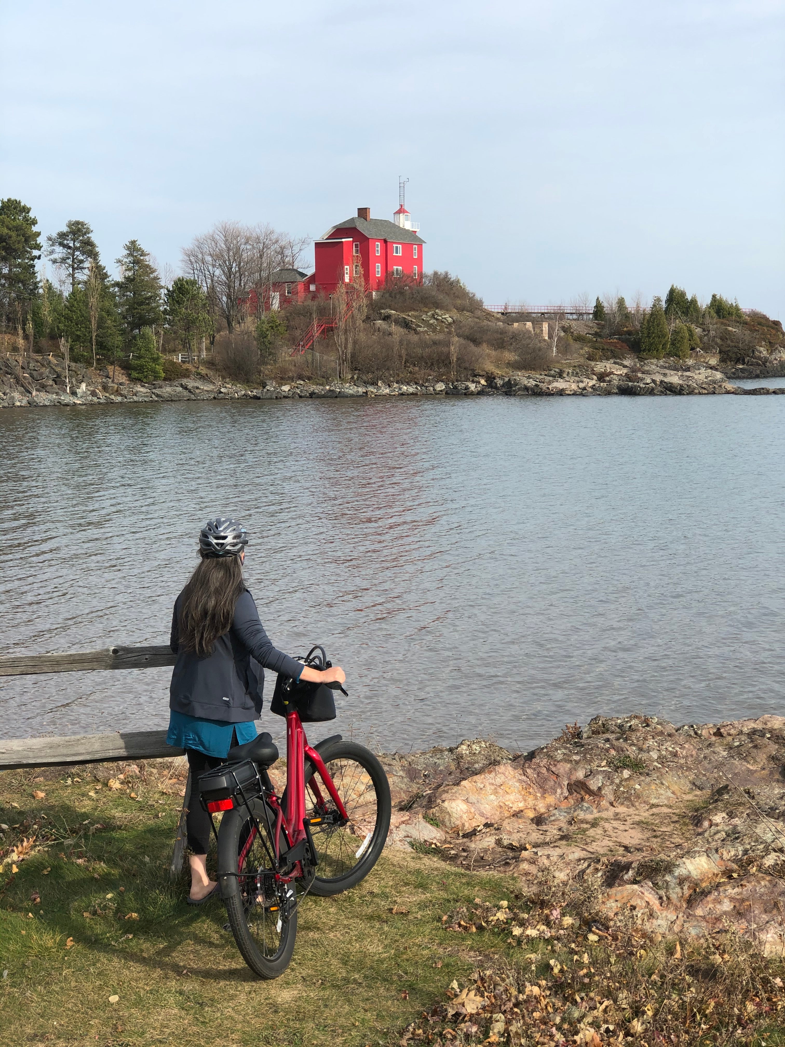 Riding an eBike in front of the red lighthouse in Marquete Michigan