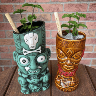 Pair-of-mint-infused-tiki-cocktails-in-custom-carved-mugs.png__PID:9238f1e3-45f3-4fcb-a2e2-a0a955eed442