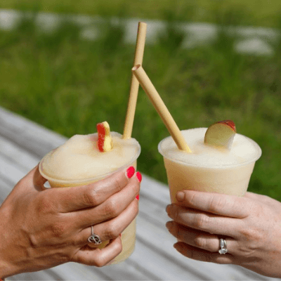 two hands cheering with frozen cocktails
