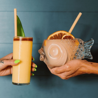 two-hands-holding-frozen-rum-and-grapefruit-frozen-cocktails