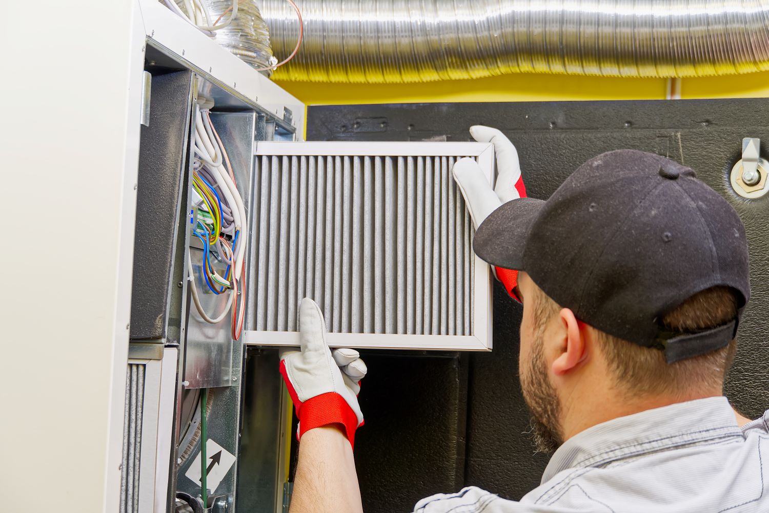 hvac specialist changing air filter in system for efficient usage