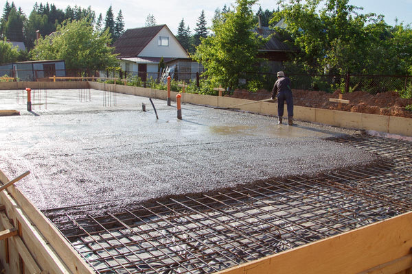 Workers install radiant heating system on top of an insulated concrete foundation 