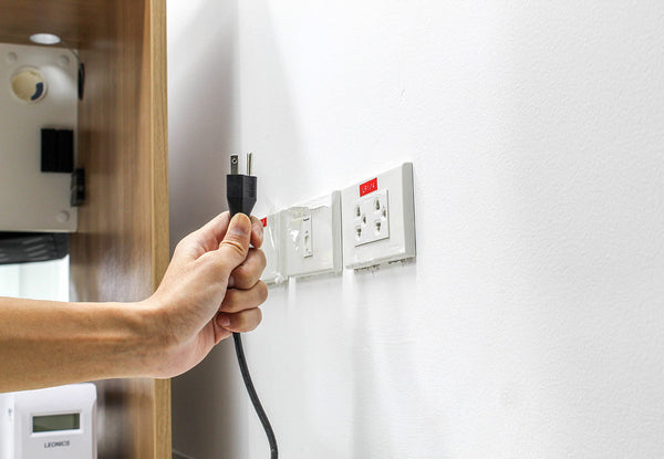 Uplugging an electric cord from the socket to save on electric costs