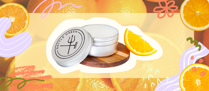 Orange & Patchouli Natural Deodorant Tin on Oranges background with cartoon graphics