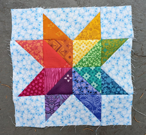 Quilt block with rainbow star on light blue background