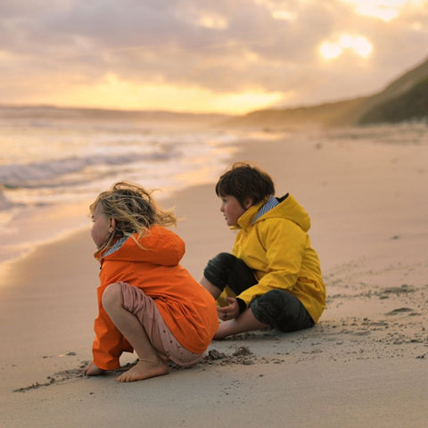 Boys wearing raincoats on the beach