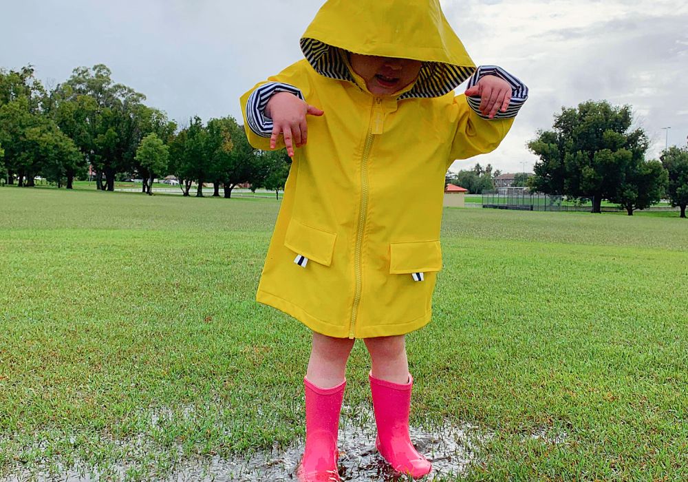 Puddle jumping toddler wearing gumboots