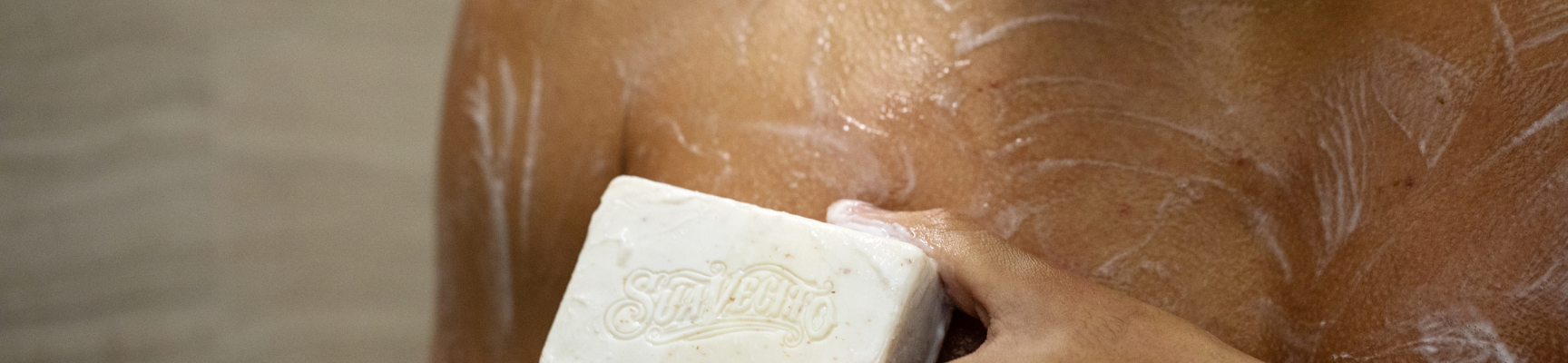 man lathering suavecito body soap on chest
