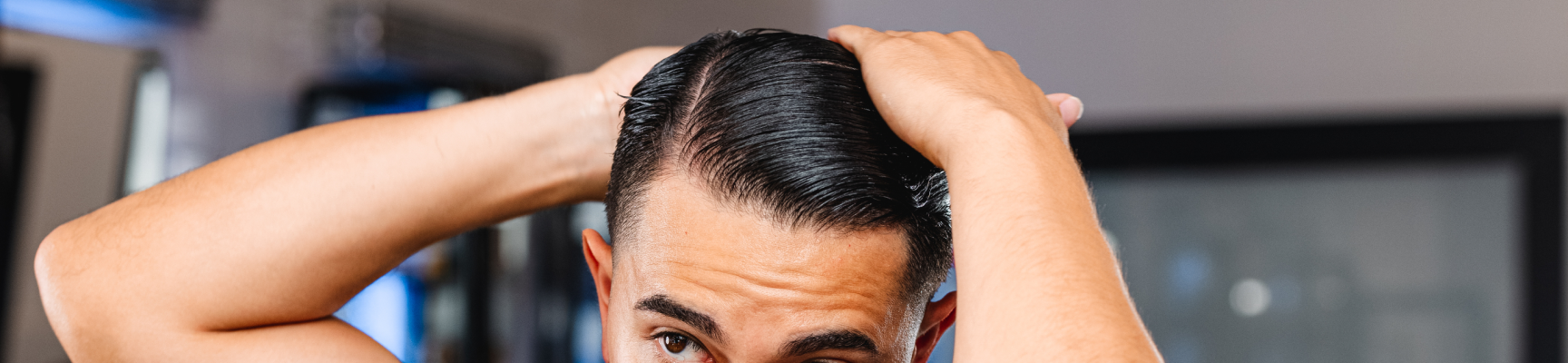 man combing side part into hair