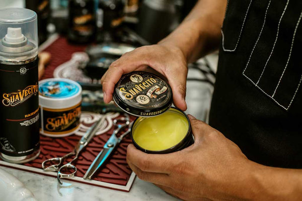 Barber openeing can of Suavecito Oil Based Pomade.