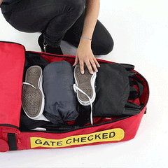 woman unzipping travel bag to reveal it holds more than just a folded stroller