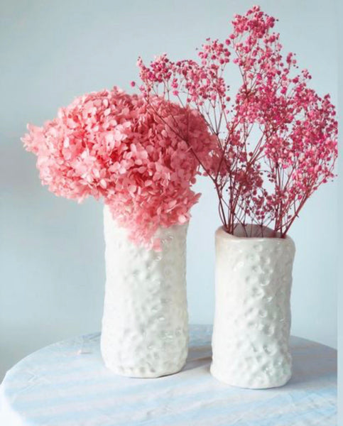 White noss vases with pink flowers