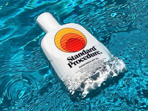 Daily-wear sunscreen bottle floating in a clear blue swimming pool