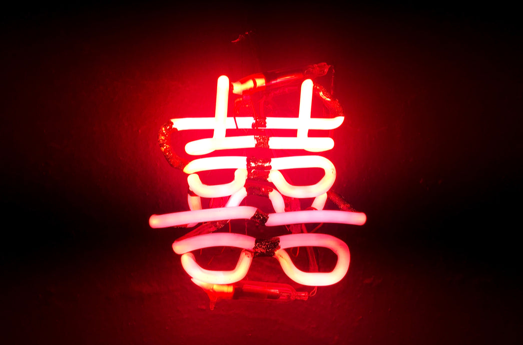 neon sign showing double happiness chinese characters. Red on a black background