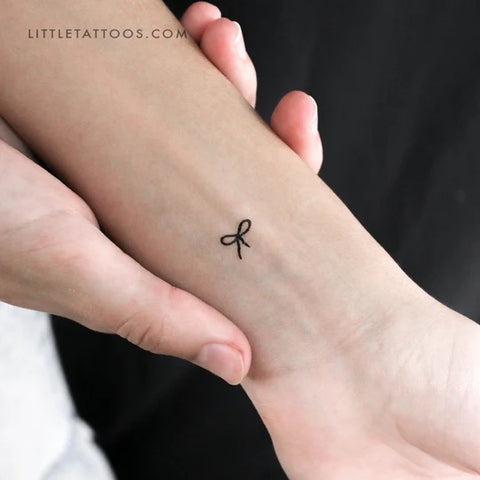 Bow Tattoos: Tiny fine line bow tattoo