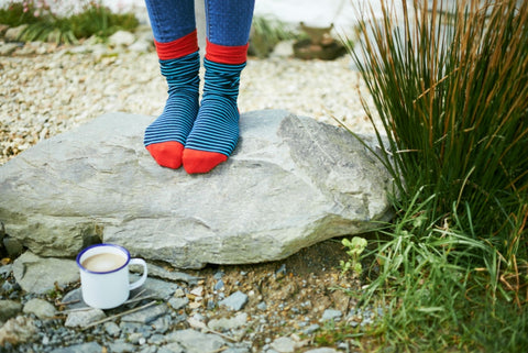 woman standing on a rock in a pair of striped socks