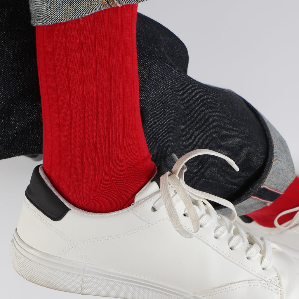 man wearing red cotton ribbed socks and white trainers