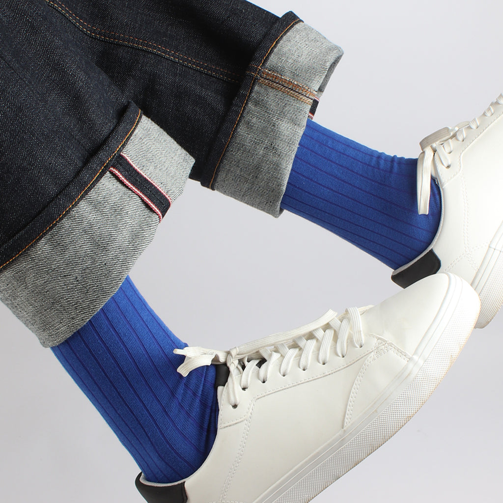 man wearing cobalt blue ribbed socks with white trainers