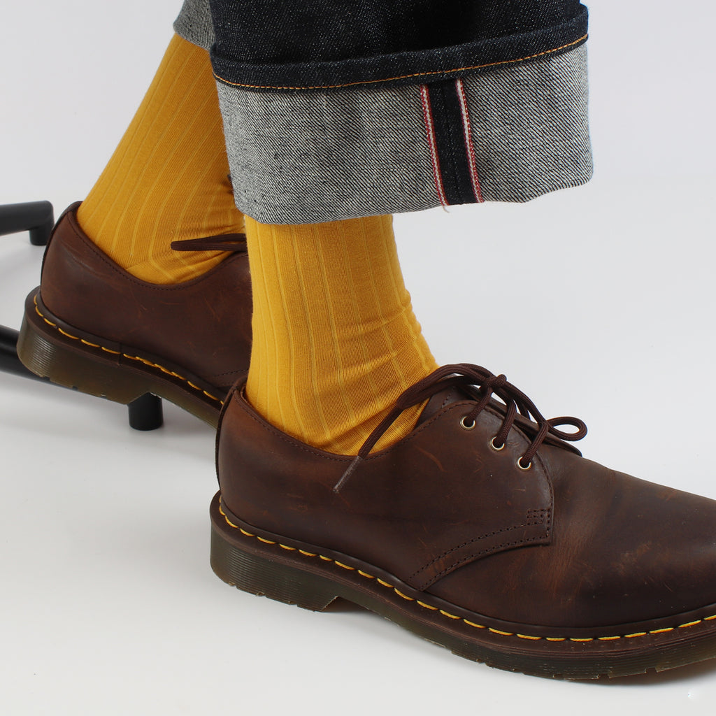 man wearing yellow gold ribbed socks with brown shoes