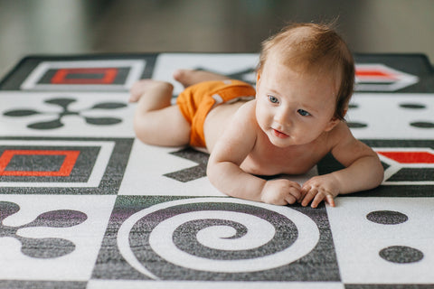 a baby having tummy time on a playmat