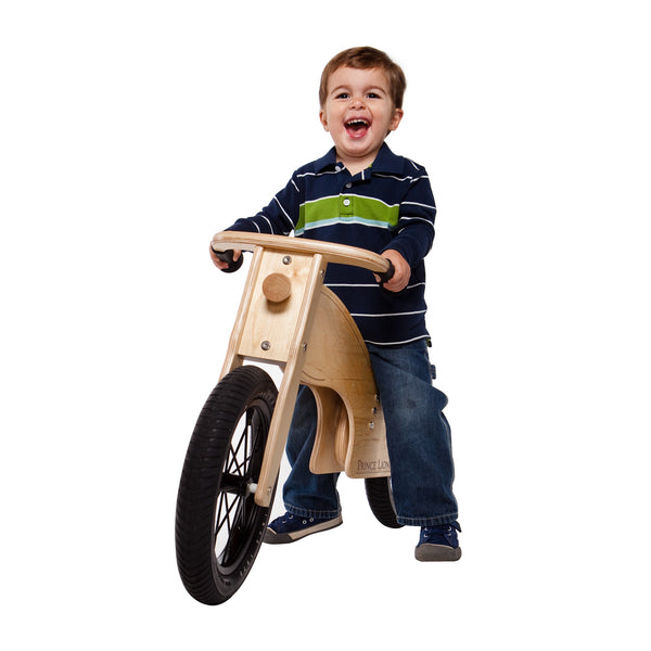 a little boy sitting on a balance bike