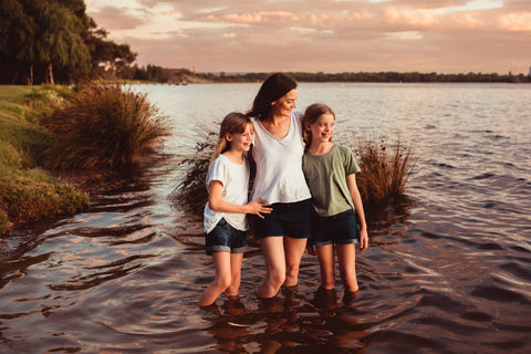 Alyce Mostert and her 2 daughters standing knee deep in the river