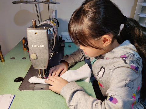 Lil lady sewing on industrial sewing machine