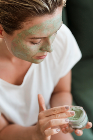 woman applying French green clay mask