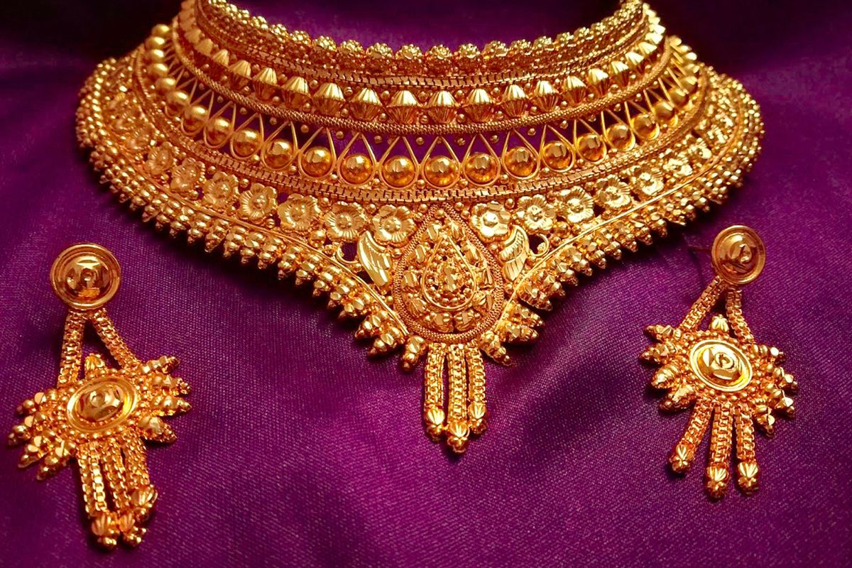 A beautiful gold jewelry set kept on soft cloth.