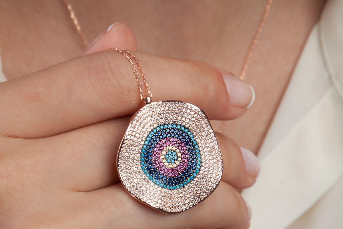 A beautiful rose gold evil eye necklace worn by a lady.