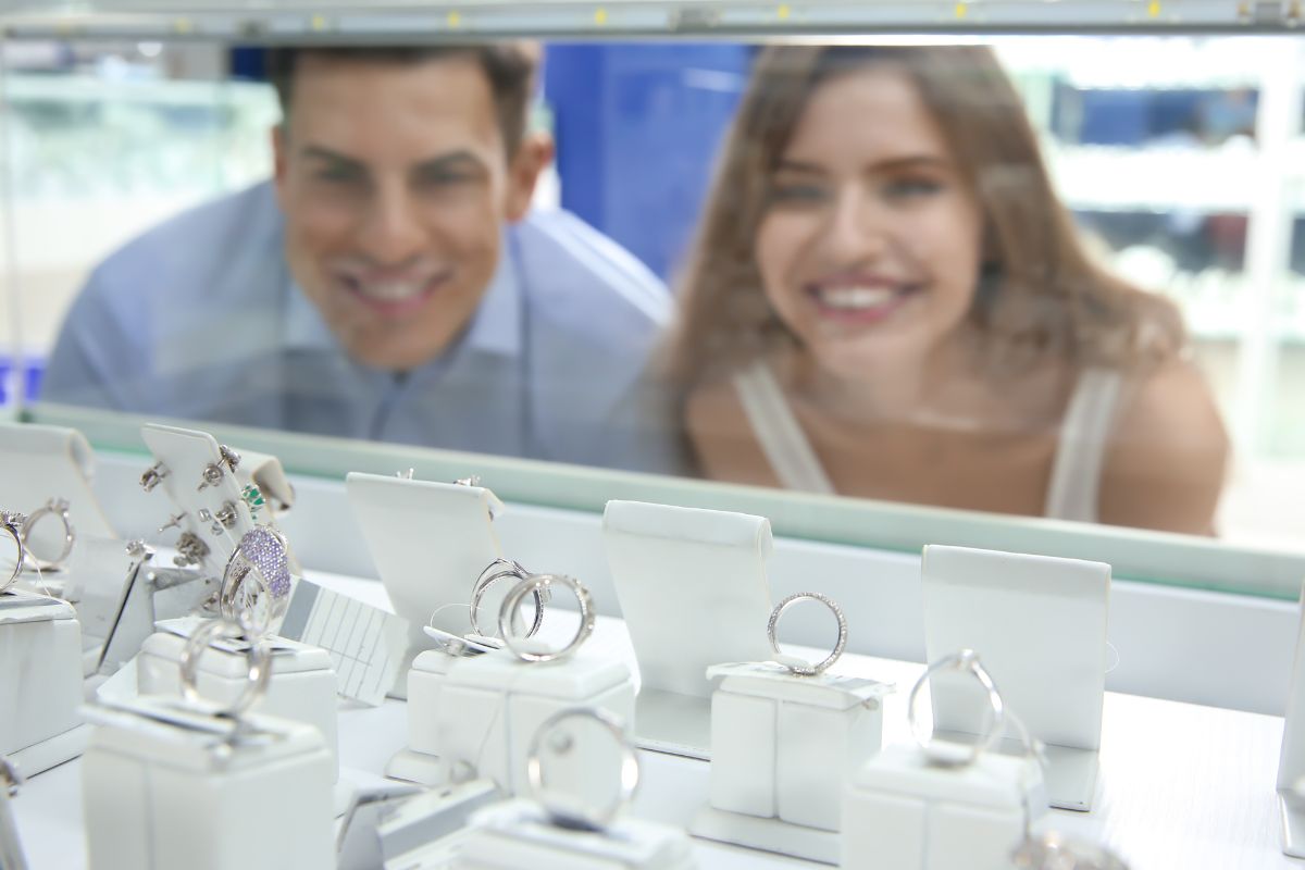 Couples selecting 6 carat diamond ring from the collection at store.